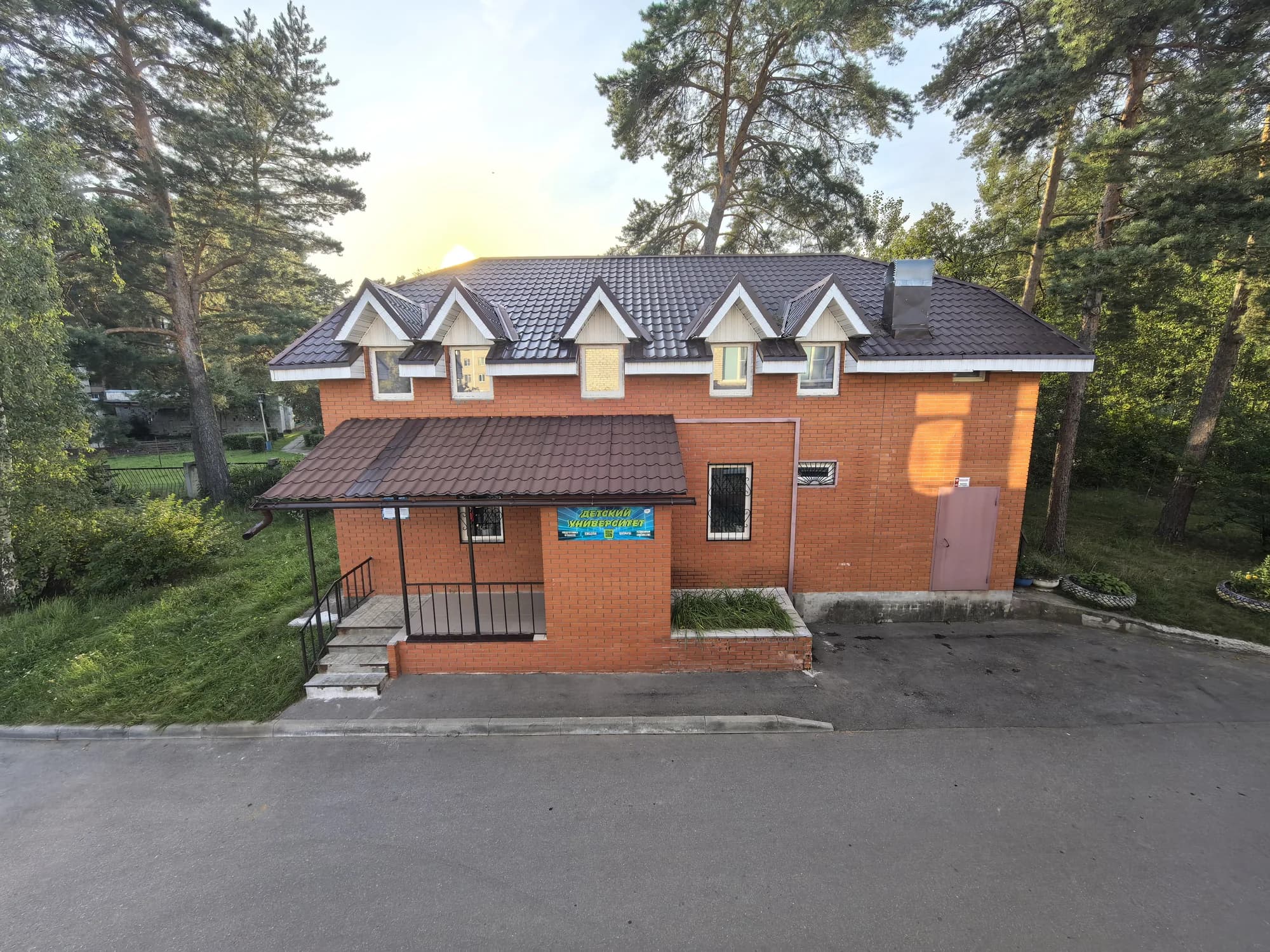 Здание Детского университета среди сосен